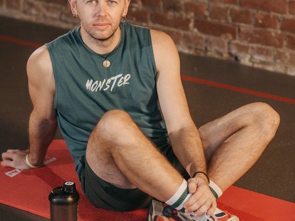 A focused man resting between sets in a well-lit gym.